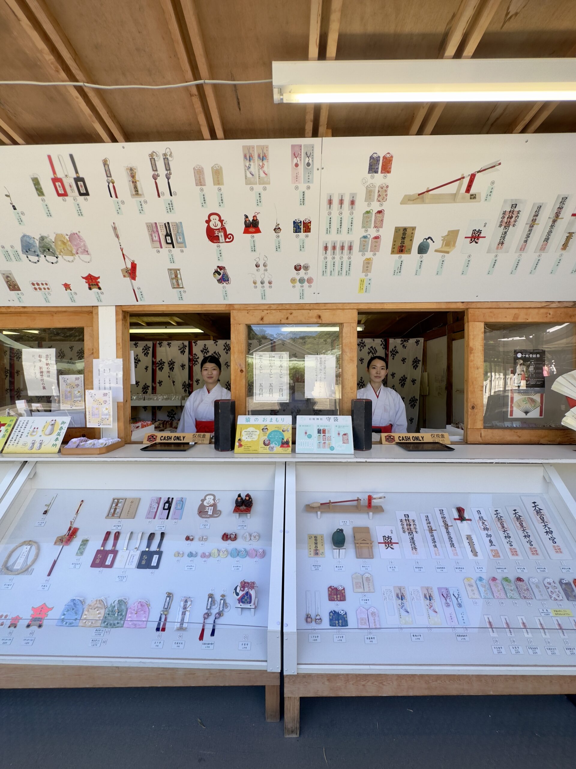 授与所の写真（たくさんの授与品と巫女が映り込むように）